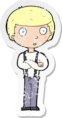retro distressed sticker of a cartoon staring boy with folded arms