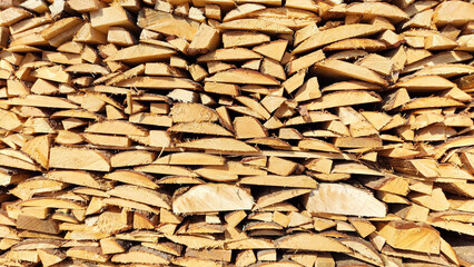 Woodpile with wooden boards, firewood. Abstract background, texture, frame, copy space. Pile and pile of old wood for construction and burning on fire, heating