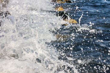 Beautiful foamy waves on the blue sea. Brilliant drops of the sea.