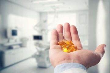 Obraz premium Dietary supplement concept, young hand hold pills