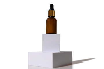 Cosmetic lotion in a glass container. On a white square podium.