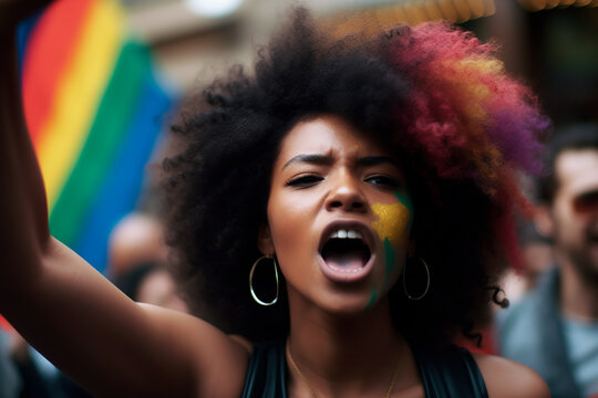 Close-up of a black girl with afro hair with her face and hair painted in color at a gay pride demonstration. Defending the rights of the lgbtiq+ community