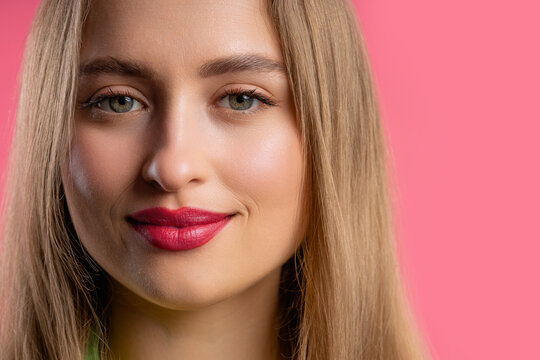 Pretty blonde woman, big lips on pink background. Smiling natural healthy girl