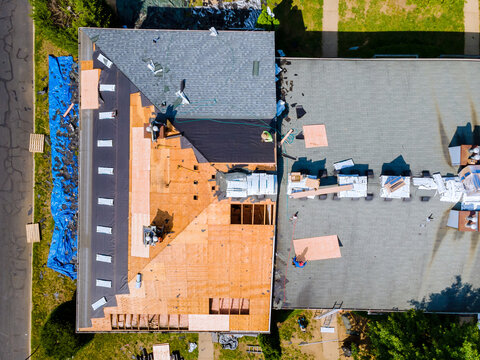 An apartment building roof was repaired by replacing old roof with new shingles and plywood