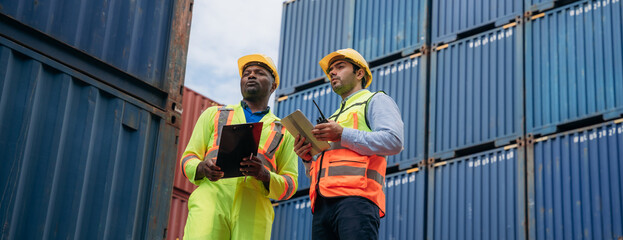 Foreman checking inventory or task details at Container cargo harbor. Logistics concept inside the shipping, import, and export industries.