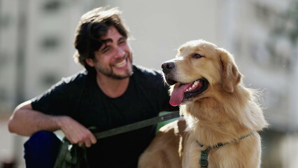 One young man posing for camera with his Golden Retriever Dog at park during sunny day. Person enjoying weekend activity with canine companion