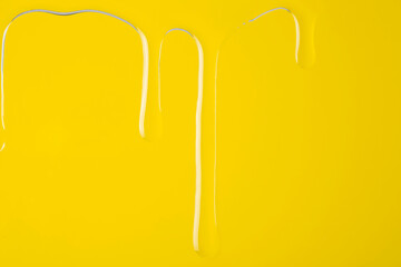 Honey flows down the surface on a yellow background.