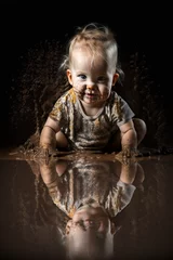 Fotobehang Kind spielt vergnügt lachend im Dreck Schlamm und ist glücklich, ai generativ © www.freund-foto.de