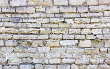 Old stone wall damaged from sandstone, blocks.Ancient wall, structure made of bricks. Antique building.