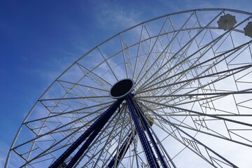 Fototapeta premium Riesenrad vor blauem Himmel bei Sonne am Abend im Frühling