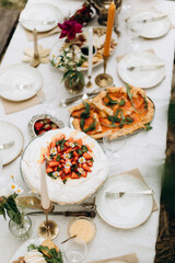 top view of the served table with snacks. decorated table with white tablecloth and plates	
