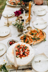 top view of the served table with snacks. decorated table with white tablecloth and plates	
