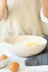 Cooking eggs with women's hands in a bowl of flour. Making a delicious breakfast. 
