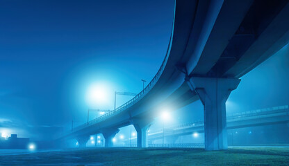 Bridge for cars or trains. Major road junction. Overpass on supports at night. Transport...