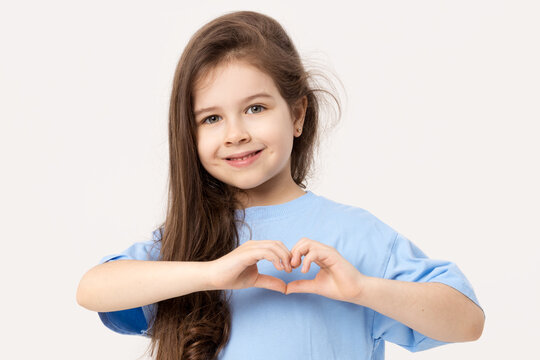 Portrait of positive child girl showing heart sign smiling isolated white background