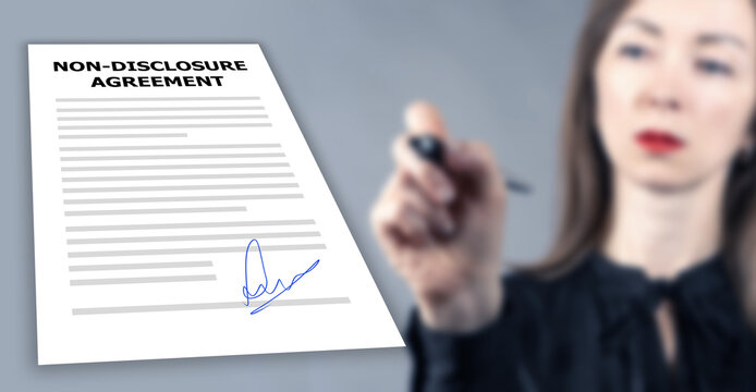 Non-disclosure agreement. NDA agreement. Businesswoman signs document. Paper with NDA rules. Non disclosure agreement logo on contract. NDA to protect company data. Selective focus.