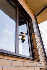 Cleaning window using portable vacuum windows cleaner. Washer of cleaning service cleans outside of...