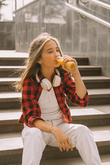cool girl holding juice bottle outdoors