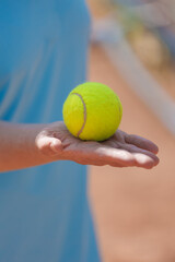 person holds tennis ball in his hands.tennis court made of red clay soil with markings for game or competition. sports and recreation, professional performance champions in lawn tennis with rackets