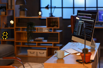 Programmer's workplace with computer in office at night