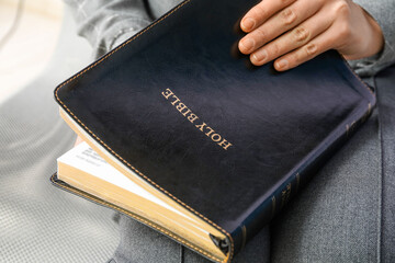 Woman holding Holy Bible, closeup