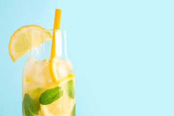 Glass with fresh lemonade on blue background