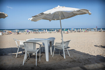 Chairs and tables placed on the beach of Gandia.