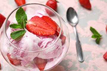 Glass bowl of strawberry ice cream on grunge background, closeup