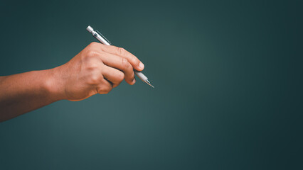 Man hand holding a pen and writing on blank background and copy space for text or picture.