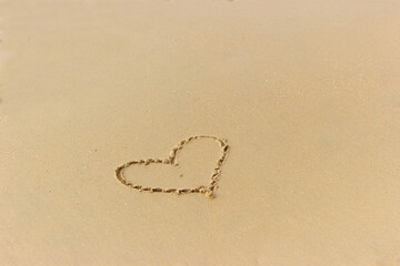 Heart drawn on the wet sand on the beach. Concept of love; romance; feelings.