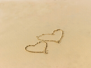 Hearts drawn on the wet sand on the beach. Concept of love; romance; feelings.
