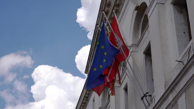 European flag with other flags behind on the facade of the building