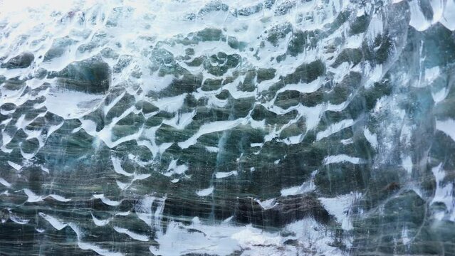 Massive ice blocks inside crevasse, transparent vatnajokull ice caves in iceland. Beautiful blue glacier on wintry frozen path, icy rocks covered in frost with cracked texture. Handheld shot.