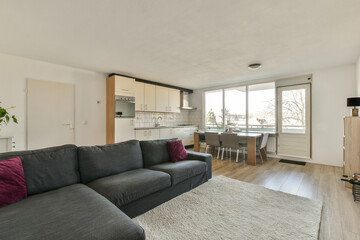 a living room with couches and a kitchen in the back ground is an open space that has been used as...