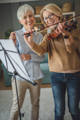 Private music teacher give violin lesson mature senior woman at home