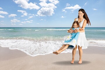 Fototapeta na wymiar Playful young happy mother with child at beach