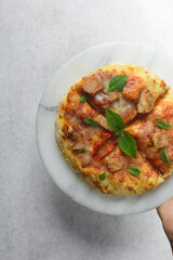 Homemade mini pizza with sausage, basil and cheese, small individual pizza