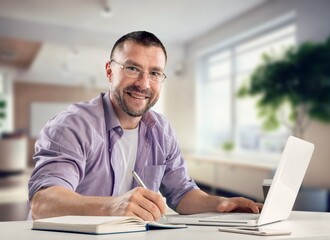 Fototapeta na wymiar Happy young business man using laptop