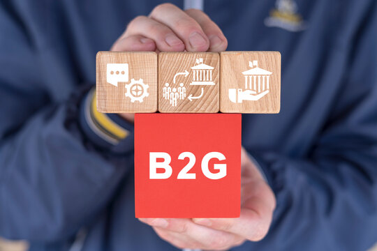 Man holding colorful blocks with icons and abbreviation: B2G. Concept of B2G - Business To Government. Business governance marketing organization process.