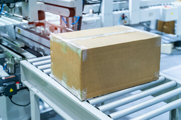 cardboard box of product packaging is moving on conveyor belt of automatic packing machine in the manufacturing factory