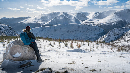 Resting hiker, admiring mount Albert panorama in the distance on a wonderful winter day, Gaspesie...