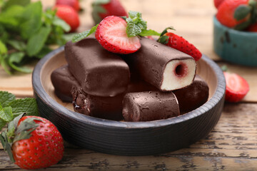 Delicious glazed curd snacks with fresh strawberries and mint on wooden table, closeup
