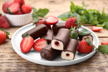 Delicious glazed curd snacks with fresh strawberries and mint on wooden table