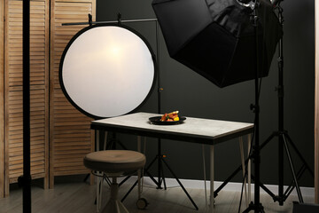 Composition with baked chicken, parsnip and strawberries on grey table in professional photo studio. Food photography