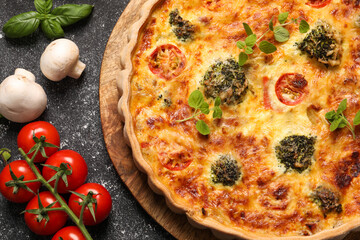 Delicious homemade vegetable quiche, oregano, tomatoes and mushrooms on black table, flat lay