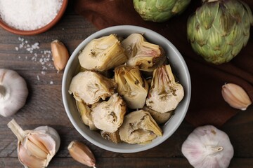 Fototapeta premium Pickled and fresh artichokes on wooden table, flat lay