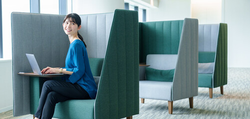 パーテーションエリアで仕事をするビジネスウーマン