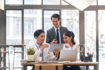 Group of happy business people using digital tablet while collaborating on a new project in  modern workspace.