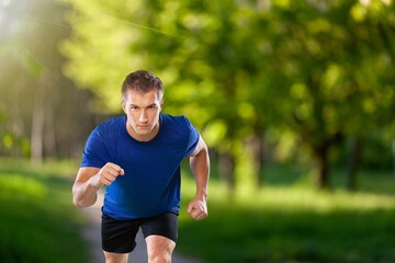 Fototapeta premium Happy young man running in city park