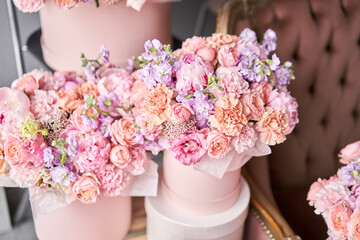 Flowers as a gift to your beloved woman. A gift set of boxes with flowers in a beautiful interior on the background of a sofa. The flower room. A box of flowers for Mother's Day.